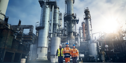 Close up picture of an engineer in front of a refinery